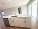 Modern kitchen island featuring white cabinets, stainless steel appliances, and quartz countertops at 4524 Sw 110Th St, Ocala, FL 34476