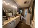 Bathroom featuring double sinks, modern lighting, and wood-look floors at 4580 Sw 110Th Ln, Ocala, FL 34476