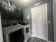 Laundry room with modern washer and dryer, overhead cabinets, and a 