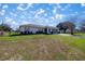 Well-maintained single-story home with a spacious front yard on a sunny day with a blue sky at 4858 Sw 143Rd Loop, Ocala, FL 34473