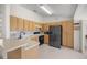 Well-lit kitchen featuring modern black appliances, light colored wood cabinets, and tile backsplash at 4858 Sw 143Rd Loop, Ocala, FL 34473