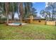 Backyard with a kidney-shaped pool, mature landscaping, grass, and fenced yard at 5205 Ne 3Rd St, Ocala, FL 34470