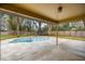 Covered patio overlooking the pool, landscaping, and fenced-in backyard, perfect for outdoor entertaining at 5205 Ne 3Rd St, Ocala, FL 34470