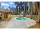 Backyard featuring a kidney-shaped pool, patio, mature trees, and a storage shed in a private fenced yard at 5205 Ne 3Rd St, Ocala, FL 34470