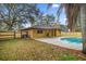 View of home's backyard featuring fenced in yard, pool, covered patio, and mature landscaping at 5205 Ne 3Rd St, Ocala, FL 34470