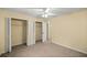 Neutral bedroom featuring carpeted floors, closets, and a ceiling fan for comfortable living at 5205 Ne 3Rd St, Ocala, FL 34470