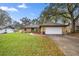 Charming single-story home with a manicured front lawn and an attached two-car garage at 5205 Ne 3Rd St, Ocala, FL 34470