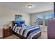 Bedroom featuring striped bedding, side table, and windows offering natural light at 5417 Sw 49Th Ave, Ocala, FL 34474