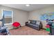 Bedroom with brown carpet, window, map, black sofa, and red chair at 5417 Sw 49Th Ave, Ocala, FL 34474