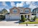 Charming two-story home featuring a three-car garage, lush landscaping, and a well-manicured front lawn at 5417 Sw 49Th Ave, Ocala, FL 34474