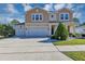 Charming two-story home with three-car garage and beautifully landscaped front yard under a sunny sky at 5417 Sw 49Th Ave, Ocala, FL 34474