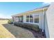 View of the lanai, backyard landscaping, and the home's green exterior at 6780 Sw 91St Cir, Ocala, FL 34481