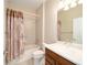 A bathroom with a tub and shower combination, featuring neutral tones and a decorative shower curtain at 6780 Sw 91St Cir, Ocala, FL 34481