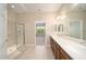 Bathroom featuring double sinks, framed mirror, a glass-enclosed shower and tile flooring at 6780 Sw 91St Cir, Ocala, FL 34481