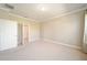 Bedroom with neutral carpet, crown molding, and access to ensuite bathroom at 6780 Sw 91St Cir, Ocala, FL 34481