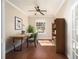 Cozy home office featuring hardwood floors, a built-in bookshelf, and a large window for natural light at 6780 Sw 91St Cir, Ocala, FL 34481