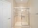 A tiled shower stall with glass doors and metal hardware provides a sleek and modern design at 6780 Sw 91St Cir, Ocala, FL 34481