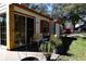 View of the back porch with sliding glass door, chairs and potted plants at 7972 Midway Drive Ter # O103, Ocala, FL 34472