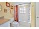 Bathroom featuring a granite vanity, a shower with decorative floral curtain, and a window at 7972 Midway Drive Ter # O103, Ocala, FL 34472