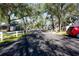 A tree-lined street with white picket fences and well-maintained lawns leads to charming homes at 7972 Midway Drive Ter # O103, Ocala, FL 34472