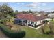 Backyard of a home with red tile roof, screened in lanai, and manicured landscaping at 8223 Sw 113Th Ln, Ocala, FL 34481