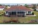 Backyard of a home with red tile roof, screened in lanai, and manicured landscaping at 8223 Sw 113Th Ln, Ocala, FL 34481