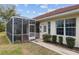 Shot of the exterior, lawn, garden, and screened patio of a property on a sunny day at 8223 Sw 113Th Ln, Ocala, FL 34481