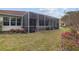 Backyard with view of screened-in lanai and lush landscaping at 8223 Sw 113Th Ln, Ocala, FL 34481