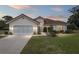 A well-kept home featuring a terracotta roof, neutral stucco, manicured lawn, and verdant landscaping at 8223 Sw 113Th Ln, Ocala, FL 34481