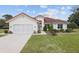 Inviting single-story home with a terracotta roof, landscaped yard, and an attached two-car garage at 8223 Sw 113Th Ln, Ocala, FL 34481