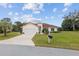 Charming single-story home featuring a terracotta-colored roof, attached garage, and well-manicured lawn at 8223 Sw 113Th Ln, Ocala, FL 34481