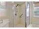 Bathroom featuring updated shower with textured glass and a safety handrail at 8223 Sw 113Th Ln, Ocala, FL 34481