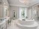 Elegant bathroom featuring round soaking tub with mosaic tile, marble counters and large walk-in shower at 8482 Nw 31St Lane Rd, Ocala, FL 34482