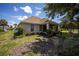 View of backyard of home from ground level with lawn, plants, and screened porch at 8779 Sw 83Rd Cir, Ocala, FL 34481