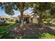 A backyard view showcasing mature trees, a well-manicured lawn, and an enclosed porch at 8779 Sw 83Rd Cir, Ocala, FL 34481