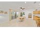 Bright dining area featuring tile floors, a ceiling fan, access to the screened-in patio, and adjacent kitchen at 8779 Sw 83Rd Cir, Ocala, FL 34481