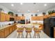 Bright kitchen showcasing tile floors, wooden cabinetry, a breakfast bar with seating, and plenty of natural light at 8779 Sw 83Rd Cir, Ocala, FL 34481