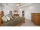 Spacious main bedroom with tray ceiling, ceiling fan, and dresser at 8779 Sw 83Rd Cir, Ocala, FL 34481