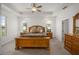 A cozy main bedroom featuring tray ceiling and ample natural light from the windows at 8779 Sw 83Rd Cir, Ocala, FL 34481