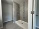 Modern bathroom with gray tiled walls, a stand-up shower, and a white shower base at 92 Locust Loop, Ocala, FL 34472