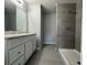 Bathroom featuring a vanity with gray countertops and a walk-in shower with tiled walls at 92 Locust Loop, Ocala, FL 34472