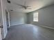 Spacious bedroom with gray tiled floor, ceiling fan, and natural light from the window at 92 Locust Loop, Ocala, FL 34472