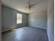 This bedroom boasts a neutral color scheme, ceiling fan, and a large window for ample natural light at 92 Locust Loop, Ocala, FL 34472