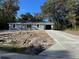 Charming single-story home featuring a gray exterior, concrete driveway and a well-maintained front yard at 92 Locust Loop, Ocala, FL 34472