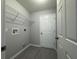 Practical laundry room featuring tile flooring, storage shelf and neutral color palette at 92 Locust Loop, Ocala, FL 34472