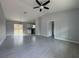 This light-filled living room has high ceilings, modern ceiling fan and gray tile flooring at 92 Locust Loop, Ocala, FL 34472