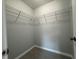 Walk-in closet with installed wire shelving for optimal storage and gray tiled floors at 92 Locust Loop, Ocala, FL 34472