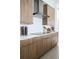 Modern kitchen featuring sleek wood cabinets, stainless steel range hood, and white countertops at 0000 Se 47Th Loop, Ocala, FL 34480