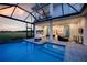 Luxury backyard with a screened-in pool, patio, and outdoor dining and cooking area at 0000 Se 47Th Loop, Ocala, FL 34480