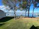 Scenic backyard view with lush lawn, mature trees, seating, and tranquil views of the lake at 11001 Se Sunset Harbor Rd # A08, Summerfield, FL 34491